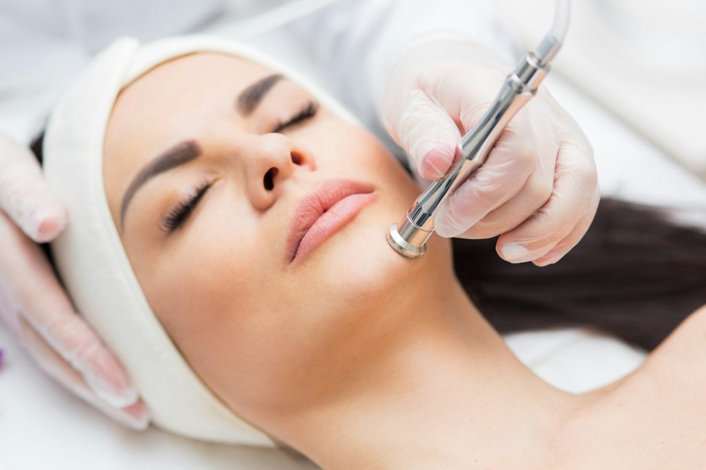 Imagen de una mujer recibiendo un tratamiento de microdermoabrasión con diamantes-Tendencias en medicina estética. Tratamientos no invasivos que están marcando el 2024-UVE medical clínica especializada en injerto capilar y tratamientos estéticos en Madrid