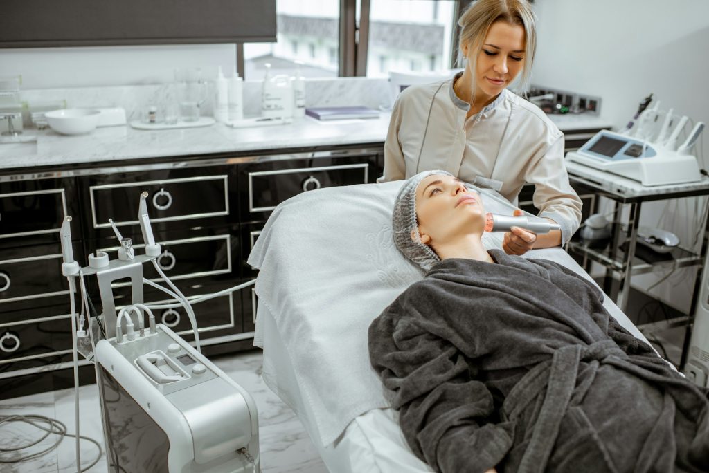 Cosmetóloga realizando tratamiento facial a una mujer no Invasivos para un Look Fresco y Natural: Uve Medical, Clinica especializada en medicina estetica y capilar